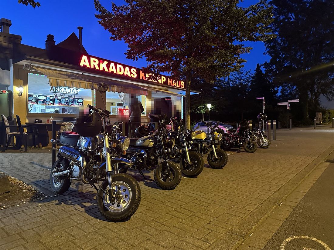 Mehrere Monkey-Minibikes nachts vor einem Imbiss